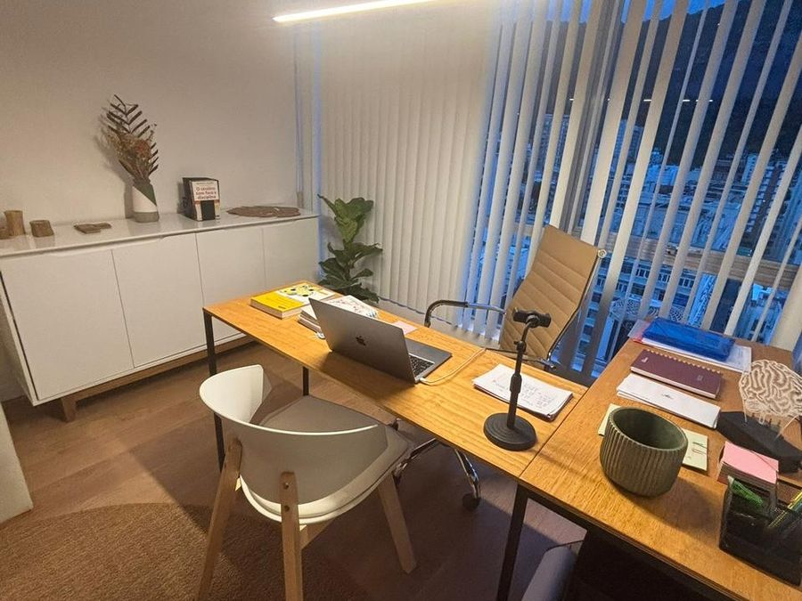 Escritório com mesa em L, cadeiras e vista da janela